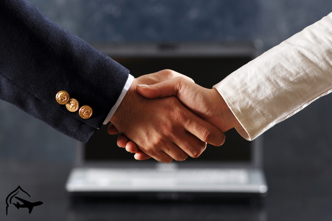 shaking hands in front of a computer